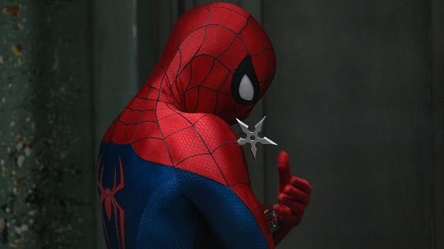 A close-up shot from behind Spider-Man in his red-and-blue suit shows him examining a metal shuriken held between his gloved fingers.