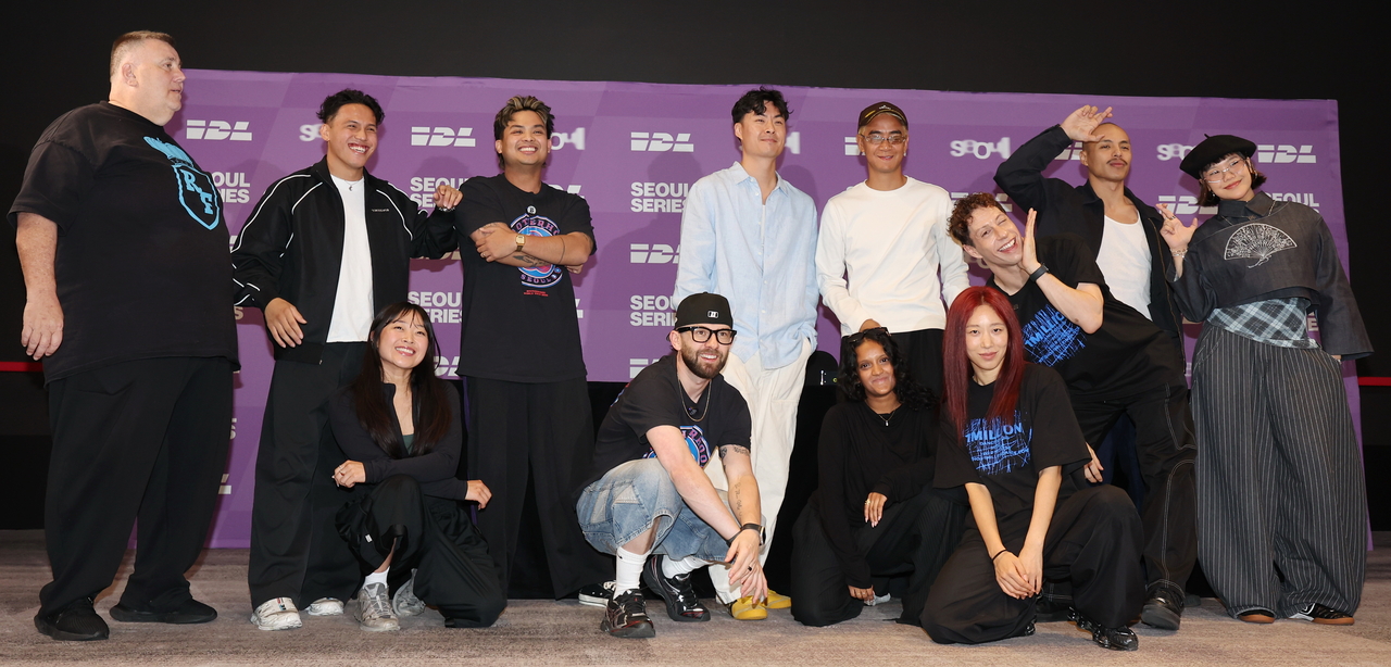 A group of people pose together on a stage in front of a purple backdrop with International Dance League and Seoul Series branding.